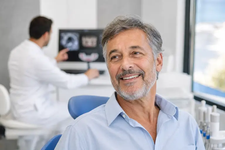 Mature patient smiling naturally after dental implant consultation at IST Smile Experts in Istanbul